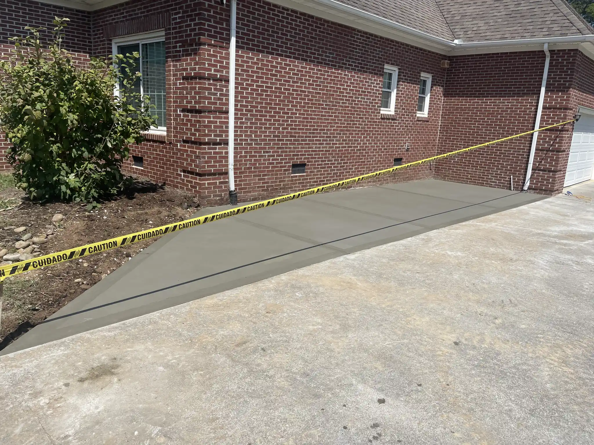 New concrete driveway and walkway finished beside a brick home in Knoxville, Tennessee
